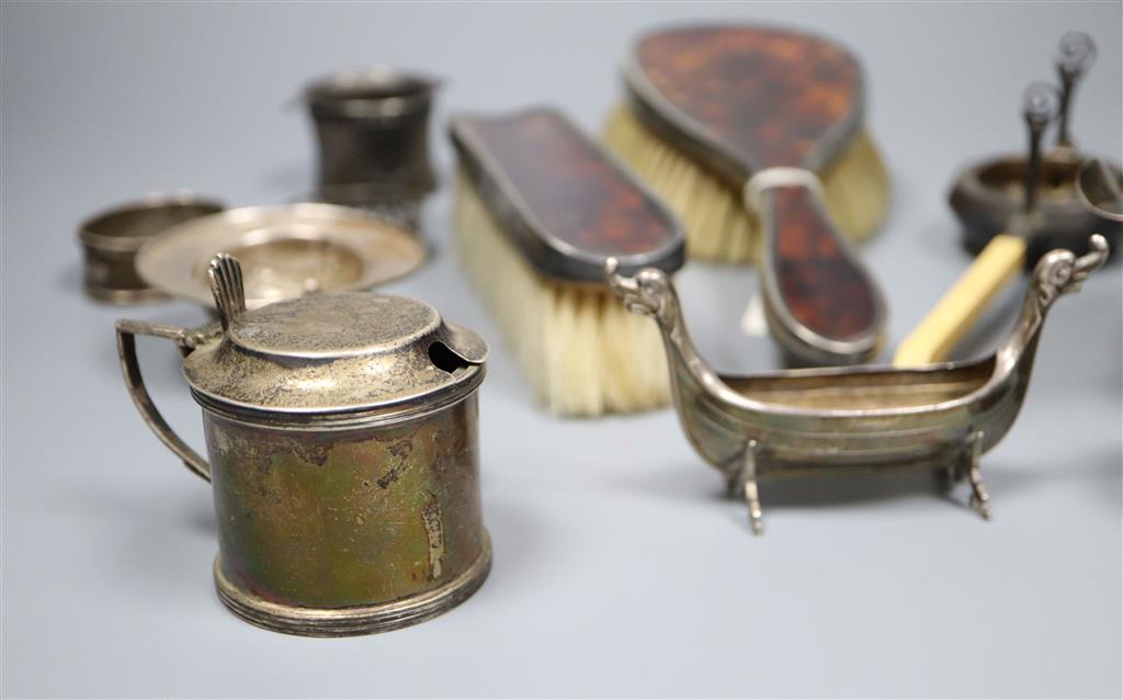 A silver mustard pot, silver sauceboat, three silver and one sterling napkin ring, two silver tea strainers etc.